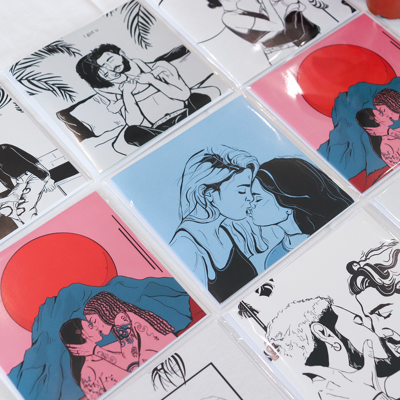 Designs by LGBTQ+ Artist Courtney L Ellis Illustrations. Picture shows gay and lesbian couples across a range of greeting cards. 